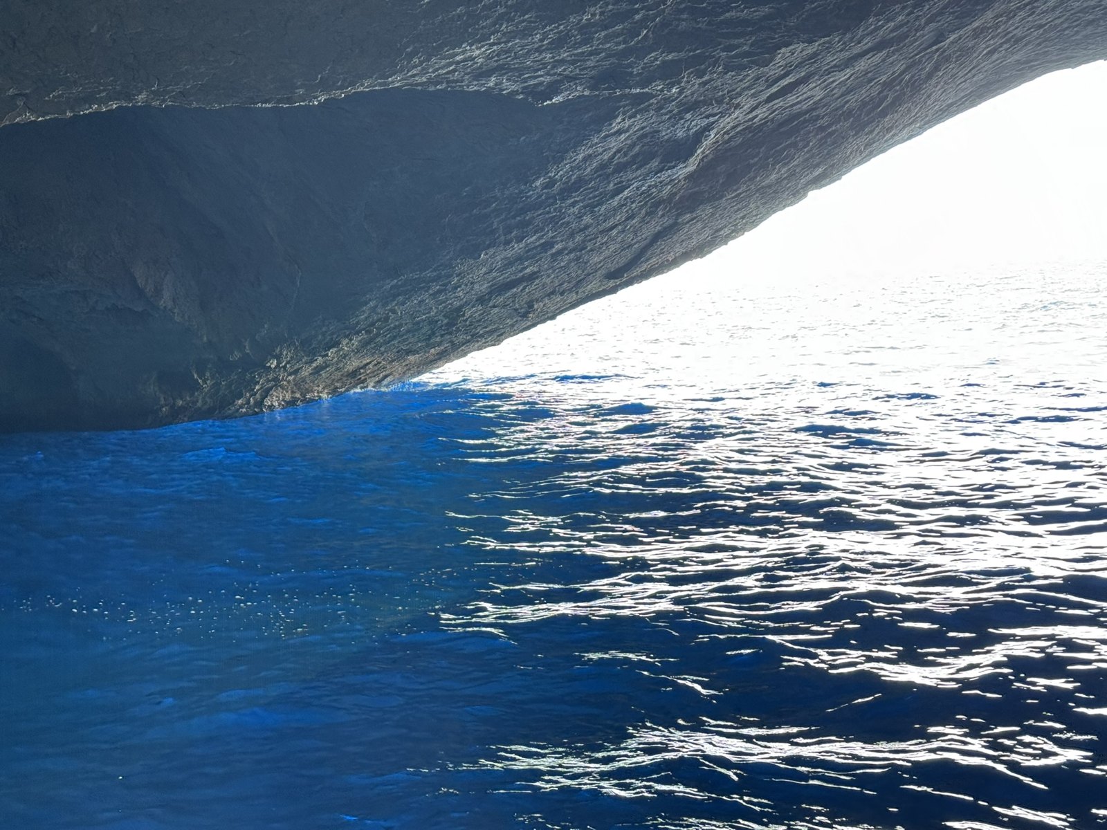 Blau leuchtendes Wasser unter dem Felsdach der Cova Blava auf Cabrera.